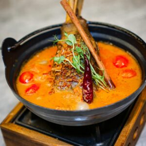 Delicious lamb shank curry with vibrant spices and herbs, perfect for food enthusiasts.